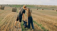 Father, child, and mother in a farm field